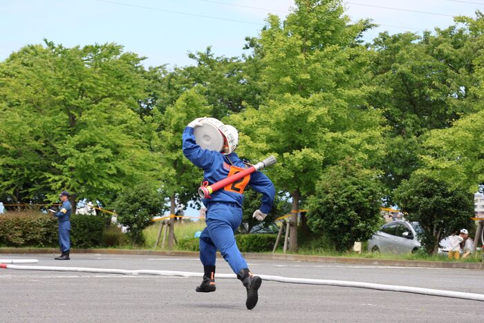 画像：ホースを搬送する団員